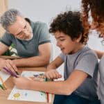 child, therapist and parent at the table talking